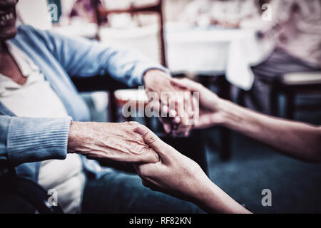 Krankenschwester kümmert sich um eine ältere Frau Stockfoto