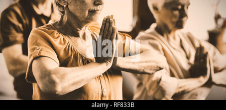 Senioren Yoga mit geschlossenen Augen machen Stockfoto