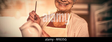 Weibliche Potter Malerei auf Krug Stockfoto