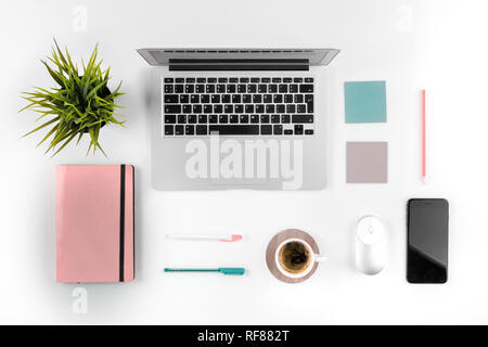 Lindgrün und rosa Farben. Flach foto Büro Schreibtisch mit Laptop, Notebook und Kaffee. Geschäftskonzept. Stockfoto