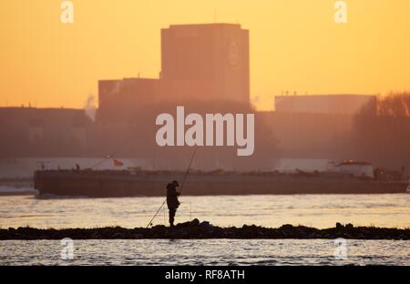 Fischer auf dem Rhein bei Sonnenuntergang, Thyssen-Krupp Stahlwerk im Hintergrund in der Nähe von Duisburg, Nordrhein-Westfalen Stockfoto