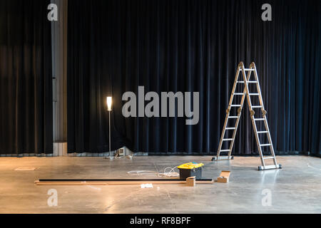 Bau im Werk oder Lager. Leiter, Reparatur von Werkzeugen, Drähten im Betonboden Stockfoto