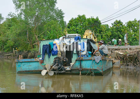 Can Tho, Vietnam - am 31. Dezember 2017. Ein Mann spricht am Telefon auf seinem kleinen Hausboot während der Einnahme eine Pause von der Arbeit Stockfoto