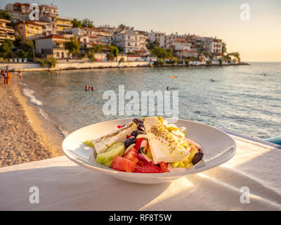Traditionelle griechische Salat auf einem Tisch in der Nähe vom Strand in einer traditionellen griechischen Taverne in Skala Marion, Thassos, Griechenland Stockfoto