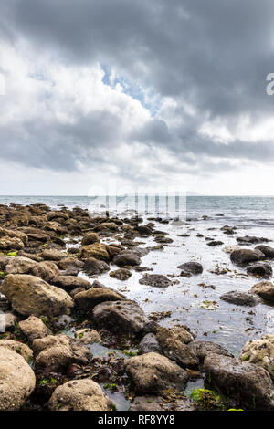 Gewitterwolken über einen felsigen Strand in Dorset, Südwestengland, GROSSBRITANNIEN, Portland Bill in der Ferne Stockfoto