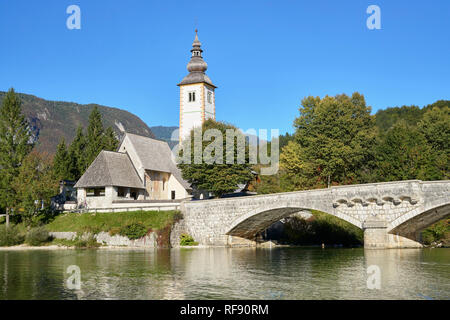 Die Kirche des Hl. Johannes des Täufers, des Cerkev Sv. Janeza Krstnika und Lake Bohinj, Ribcev Laz, Bohinj, Gorenjska, Slowenien. Stockfoto