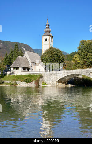 Die Kirche des Hl. Johannes des Täufers, des Cerkev Sv. Janeza Krstnika und Lake Bohinj, Ribcev Laz, Bohinj, Gorenjska, Slowenien. W Stockfoto