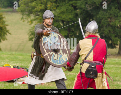 Mittelalterliche Re-enactors in Rüstung und Kostüme des 12. Jahrhunderts mit Waffen ausgestattet gekleidet nachgespielt Bekämpfung des Zeitraums Stockfoto