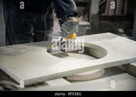 Man polieren Marmor Stein Tabelle von kleinen Winkelschleifer. Steinwerkstatt Stockfoto