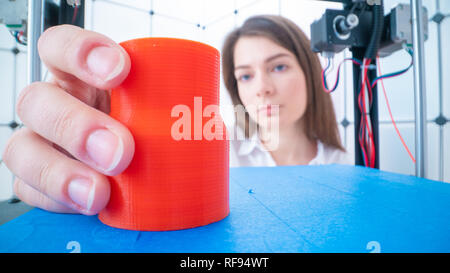 Junge Frauen Designer im 3D-Druck lab. Mädchen nimmt die fertigen Detail aus dem 3D-Drucker Stockfoto