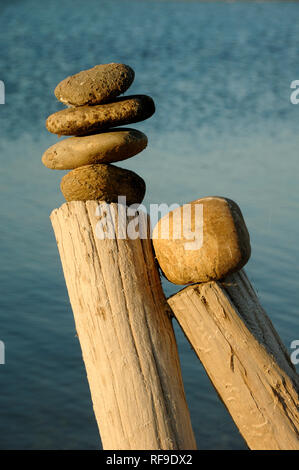 Rock Balancing, Stein, Stein oder Fels Stack Stack Erde Kunst auf Holz Beiträge in der Camargue Provence Frankreich Stockfoto