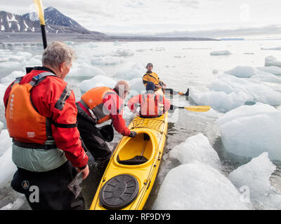 SVALBARD, Norwegen - Kajaktouristen erkunden das eisige Wasser und die unberührten Landschaften der Arktis rund um Svalbard. Diese einzigartige und abenteuerliche Form des Tourismus bietet ein Erlebnis aus nächster Nähe mit der arktischen Umgebung und zeigt die atemberaubende Schönheit und empfindliche Ökosysteme der Region. Stockfoto