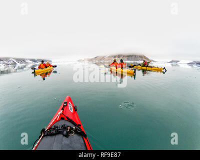 SVALBARD, Norwegen - Kajaktouristen erkunden das eisige Wasser und die unberührten Landschaften der Arktis rund um Svalbard. Diese einzigartige und abenteuerliche Form des Tourismus bietet ein Erlebnis aus nächster Nähe mit der arktischen Umgebung und zeigt die atemberaubende Schönheit und empfindliche Ökosysteme der Region. Stockfoto