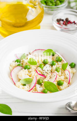 Salat mit Couscous, grüne Erbsen, Mozzarella und Rettich, Sommer gesundes Gericht Stockfoto