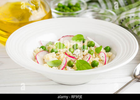 Salat mit Couscous, grüne Erbsen, Mozzarella und Rettich, Sommer gesundes Gericht Stockfoto