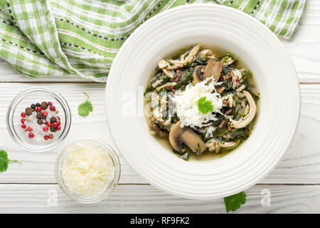 Gesunde Suppe mit Spinat, Hühnchen, Reis, Pilze und Feta, leckeres Mittagessen, Diät Lebensmittel Stockfoto