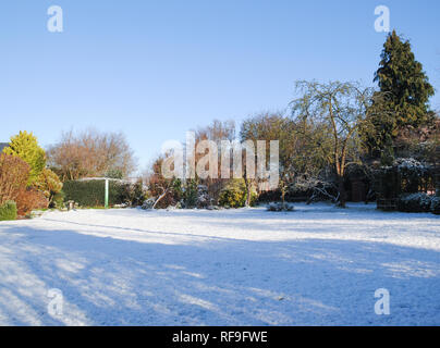 Einen knackigen Winter erschossen der Garten mit Schnee auf weiten Rasen in einem britischen Garten Stockfoto