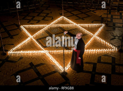 Canon Bundeskanzler Christopher Collingwood hilft sechs hundert Kerzen in der Form des David Stern Licht, im Speicher von mehr als 6 Millionen Juden durch die Nazis im Zweiten Weltkrieg ermordeten, an der York Minster in York. Stockfoto