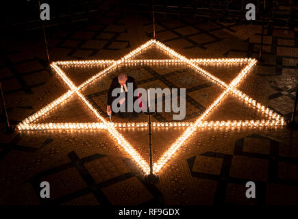 Canon Bundeskanzler Christopher Collingwood hilft sechs hundert Kerzen in der Form des David Stern Licht, im Speicher von mehr als 6 Millionen Juden durch die Nazis im Zweiten Weltkrieg ermordeten, an der York Minster in York. Stockfoto