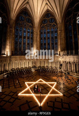 Canon Bundeskanzler Christopher Collingwood hilft sechs hundert Kerzen in der Form des David Stern Licht, im Speicher von mehr als 6 Millionen Juden durch die Nazis im Zweiten Weltkrieg ermordeten, an der York Minster in York. Stockfoto