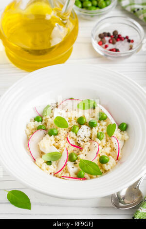 Salat mit Couscous, grüne Erbsen, Mozzarella und Rettich, Sommer gesundes Gericht Stockfoto