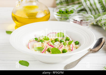 Salat mit Couscous, grüne Erbsen, Mozzarella und Rettich, Sommer gesundes Gericht Stockfoto