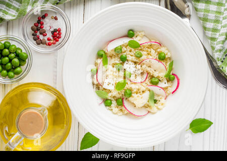 Salat mit Couscous, grüne Erbsen, Mozzarella und Rettich, Sommer gesundes Gericht Stockfoto