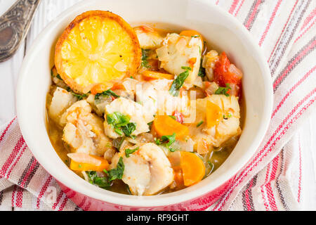 Fischsuppe mit Gemüse und Reis, leckeren, gesunden Abendessen, Zitrone, Gewürze, Brot Stockfoto