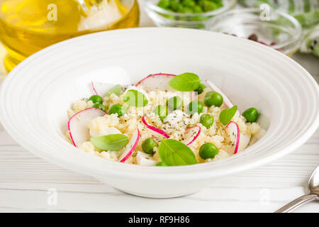 Salat mit Couscous, grüne Erbsen, Mozzarella und Rettich, Sommer gesundes Gericht Stockfoto