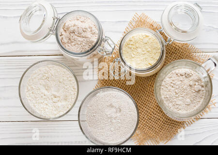 Verschiedene Mehl in Gläsern, Weizen, Mais, Roggen, Hafer, Dinkel, Flachs Stockfoto
