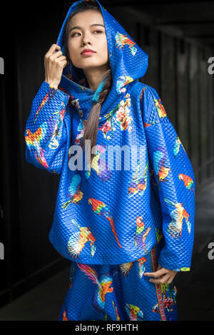 LONDON, Großbritannien - 14 September 2018: Leute auf der Straße, während der London Fashion Week. Mädchen in blau Overall mit Kapuze im Übergang posing Stockfoto