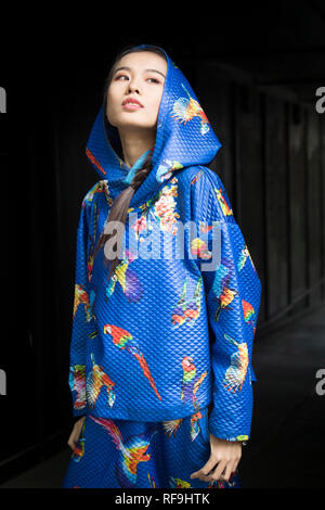 LONDON, Großbritannien - 14 September 2018: Leute auf der Straße, während der London Fashion Week. Mädchen in blau Overall mit Kapuze im Übergang posing Stockfoto