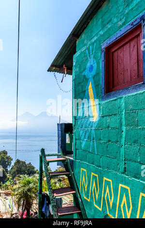 Santa Catarina Palopo, Atitlan See, Guatemala - Dezember 29, 2018: Vulkane, See & Haus mit huipil Designs bemalt Spiegel Maya traditionelles Kleid Stockfoto