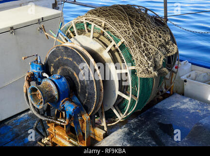 Alte und verrostete Winde Winde der Trawler Fischerboot mit einem Fischernetz. Ausrüstung für die Fischerei- und die Schleppnetzfischerei Stockfoto