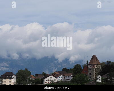 Steiniger Turm und ruhigen Wohnsiedlung am Hügel im Stadtbild Landschaften von Wolken über europäische Hauptstadt Vaduz, Liechtenstein mit bewölktem Himmel in Stockfoto