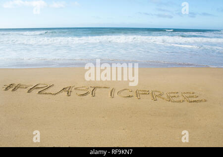 Inschrift #plasticfree auf dem Sand geschrieben am Ufer des Atlantischen Ozeans Stockfoto