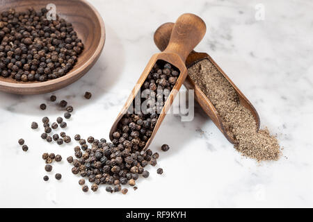 Schwarzer Pfeffer Samen und Boden Pfeffer auf Marmor Hintergrund. Gewürze zum Kochen. Piper nigrum Stockfoto