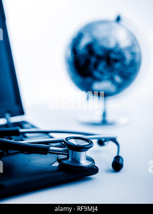 Glas Kugel und Stethoskop auf einer PC-Tastatur. blau getönten Bilder. Stockfoto