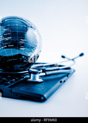 Glas Kugel und Stethoskop auf einer PC-Tastatur. blau getönten Bilder. Stockfoto