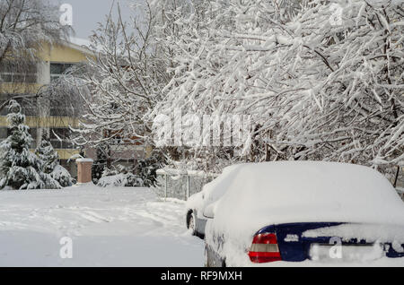 Fragment einer schmutzigen Auto unter einer Schicht von Schnee während starker Schneefall, Auto ist mit Schnee bedeckt, Stockfoto