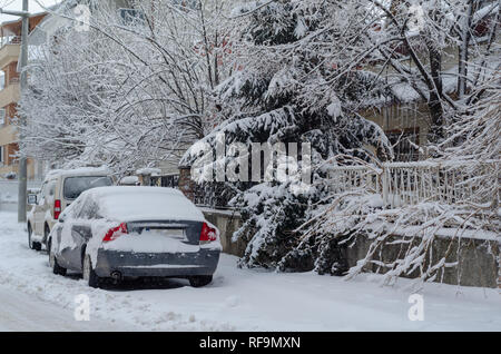 Fragment einer schmutzigen Autos unter einer Schicht von Schnee während starker Schneefall, Autos sind mit Schnee bedeckt, Stockfoto