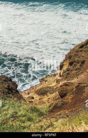 Wellen unten grasbewachsenen Steilküste in Australien. Stockfoto