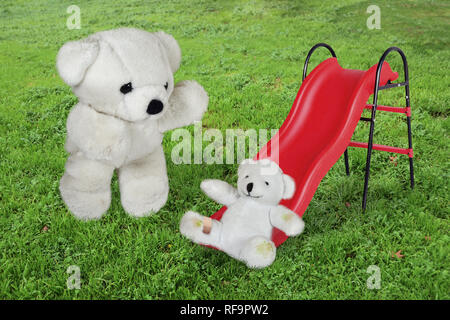 Nach Teddy Bear Cub Kind geben, eine helfende Hand auf Folie in Spielplatz Stockfoto