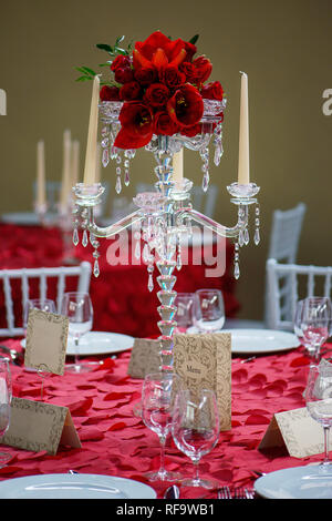 Eine schöne Kristallleuchter stil Kerzenhalter Mittelstück mit acht Scalloped bobeche für Kerzenständer und eine rote Tulpen und Rosen Blumenstrauß Stockfoto