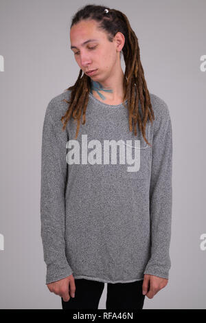 Porträt der traurige junge Mann mit Dreadlocks denken und nach unten schauen. Stockfoto