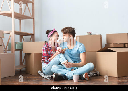 Junges Paar, der seinen neuen Platz sitzen Sandwiches essen, Tee trinken, Reden Lachen heiter Stockfoto