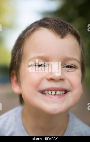 Im freien Nahaufnahme Portrait von lächelnden sommersprossigen Jungen mit dunklen Haaren und braunen Augen Stockfoto