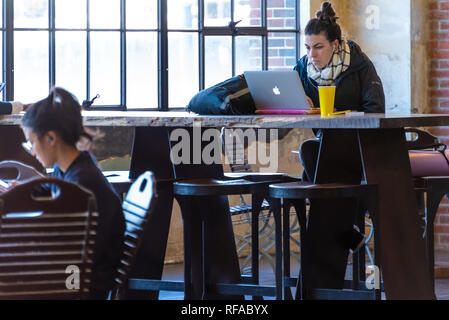 Frau mit Laptop Computer in der zentralen Halle in Ponce City Market in Atlanta, Georgia. (USA) Stockfoto