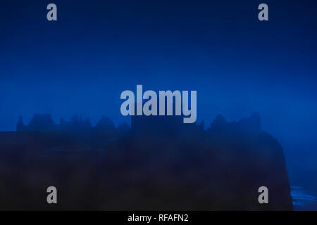 Dunnottar Castle im Nebel in der Nacht, zerstörte mittelalterliche Festung in der Nähe von Stonehaven an der Felswand entlang der Nordseeküste, Aberdeenshire, Schottland, Großbritannien Stockfoto