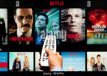 Männliche Hand, eine Fernbedienung und Netflix Stockfoto